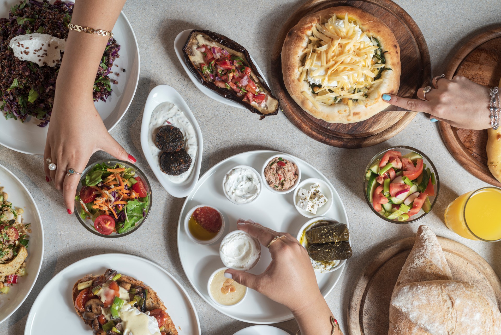 תמונת אווירה עם מבחר סלטים מטבלים גבינות ומאפה